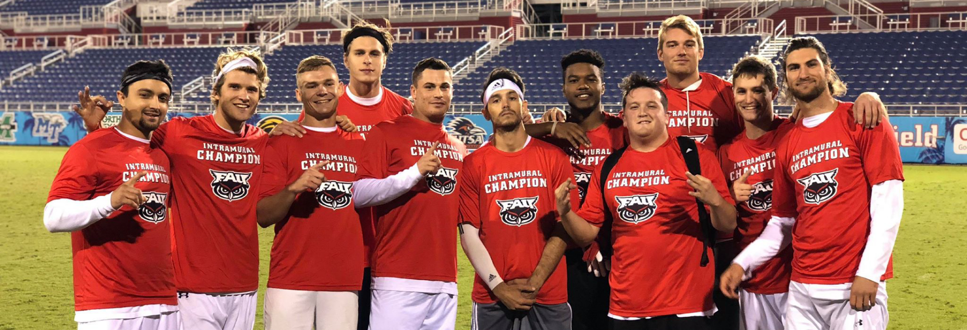 Group wearing red intramural champion shirts on field