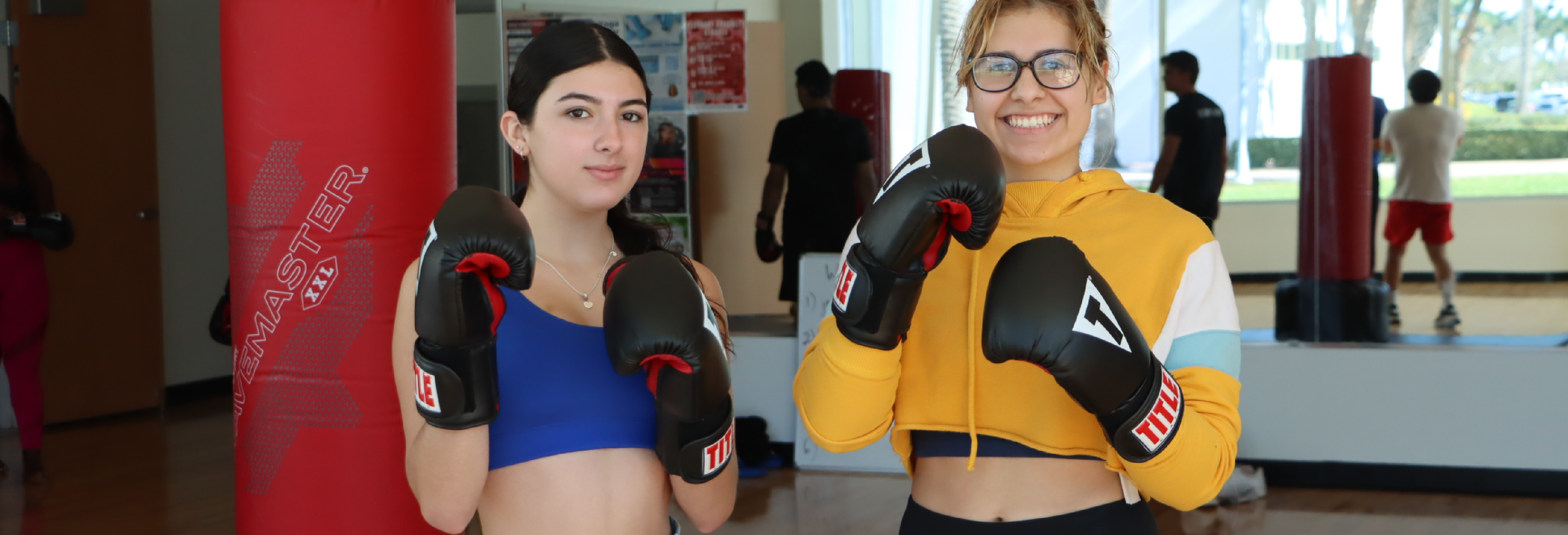 Two women posing with boxing gloves