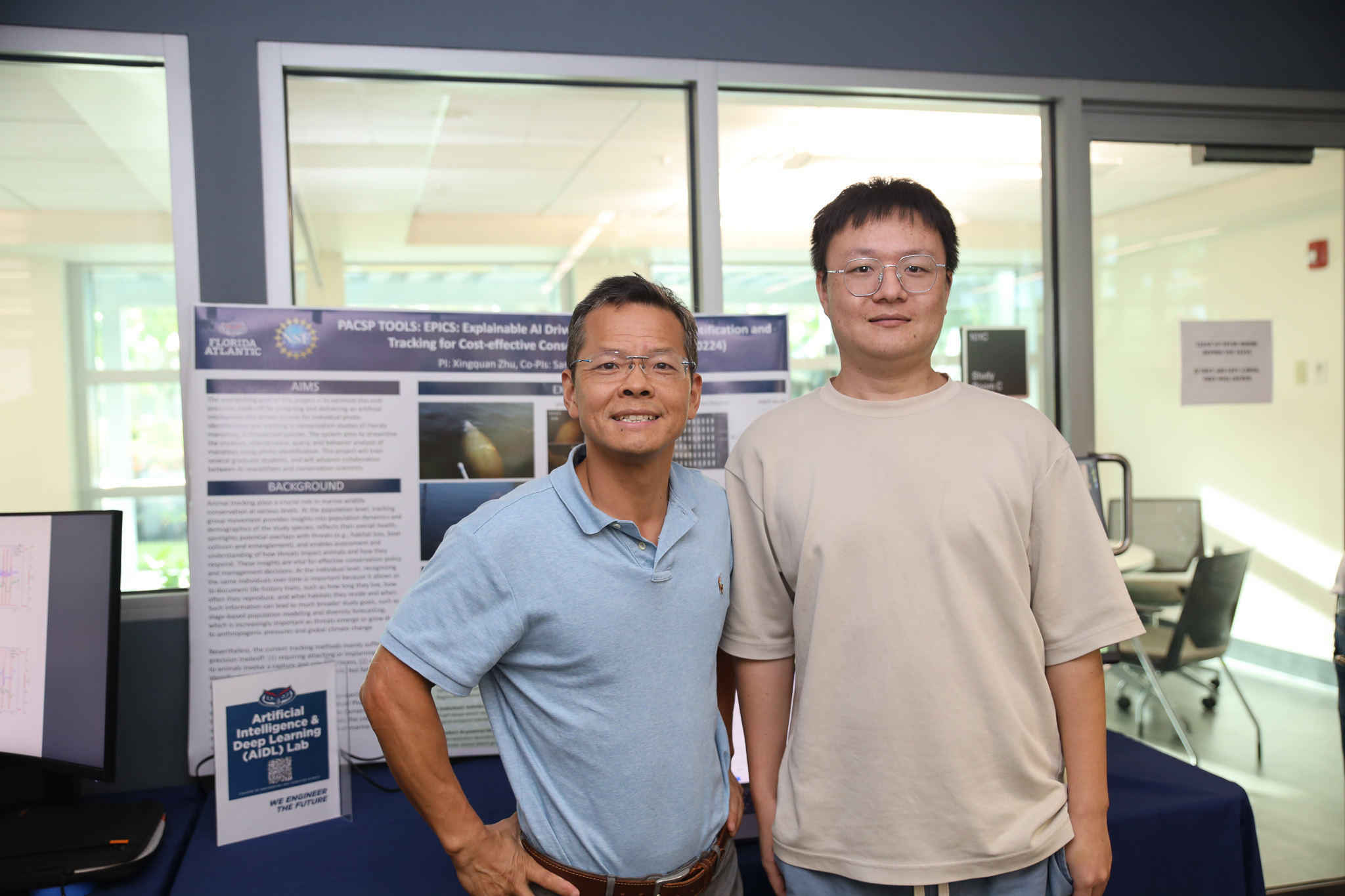 Two people in front of poster