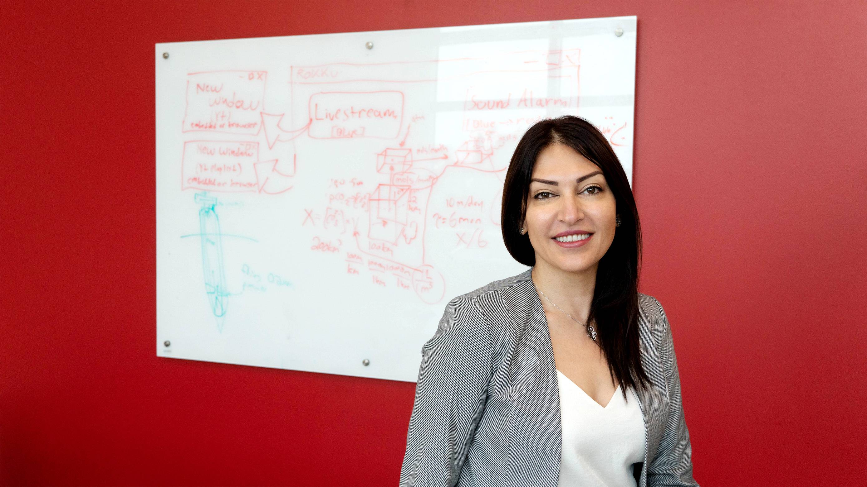 Researcher smiling in front of a whiteboard