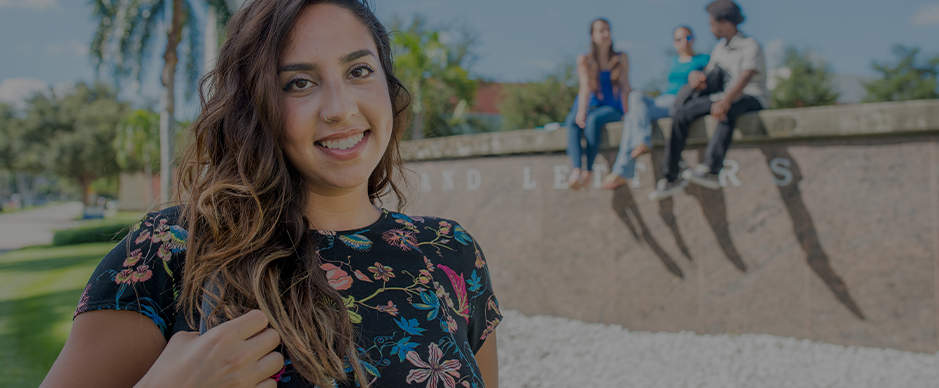 Female student looking and three students sitting in the background