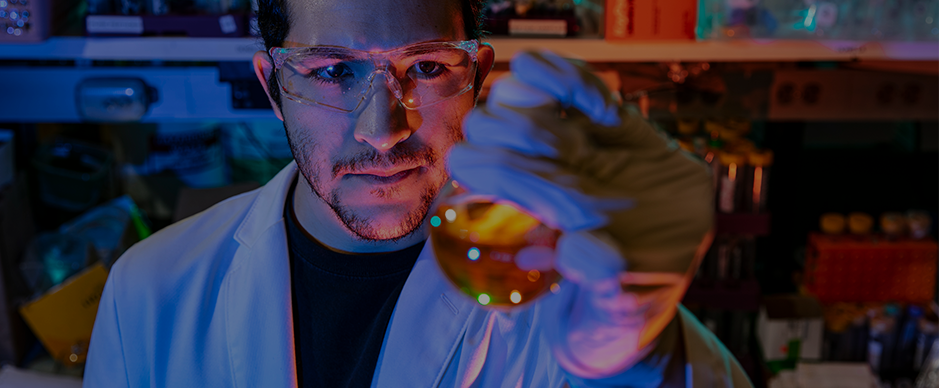 Male student in a laboratory examining an object