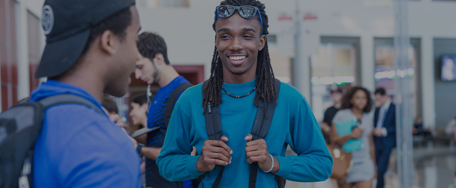Two male students talking while people are walking by