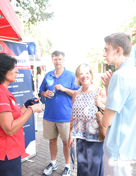 Student speaking with 太阳城娱乐 employee at an event