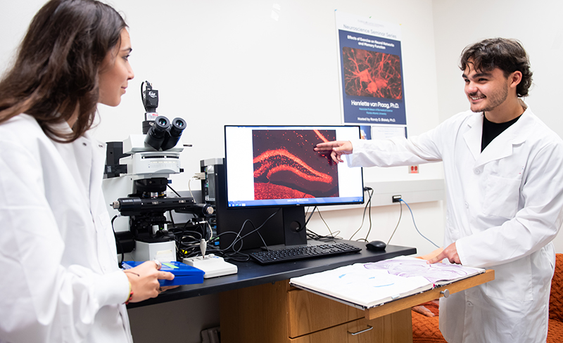 two people wearing white lab coats in lab setting