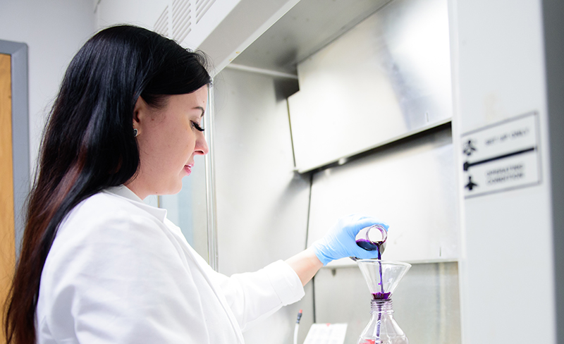 person wearing white lab coat in lab setting