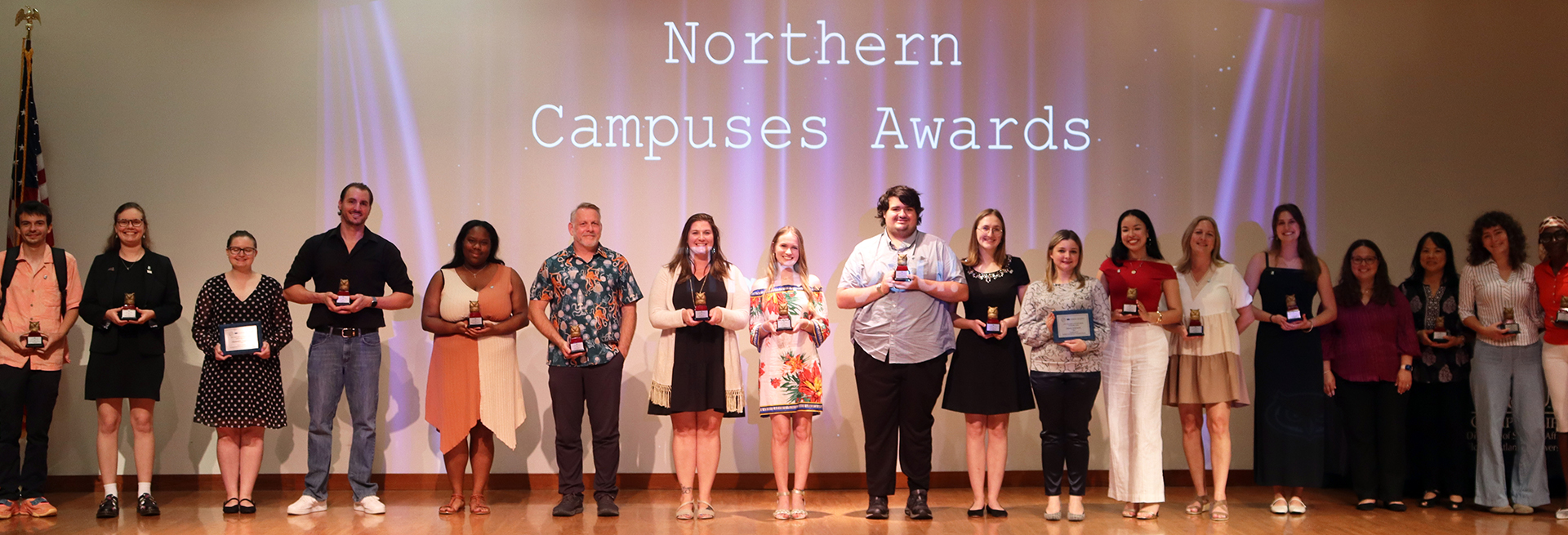 Award recipients standing on stage holding trophies