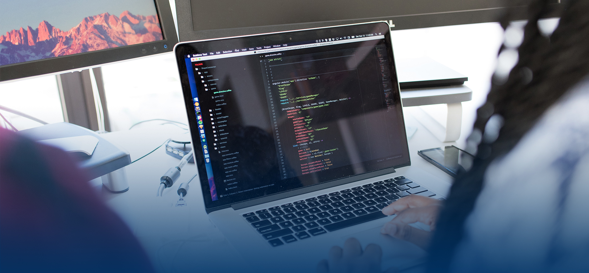 Person looking at code on a laptop